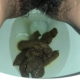 A very cute girl shits a long hanging log into the toilet from under ass late in the clip, with product in the bowl. Filmed from a between the legs perspective. Vertical format video. Over a minute.